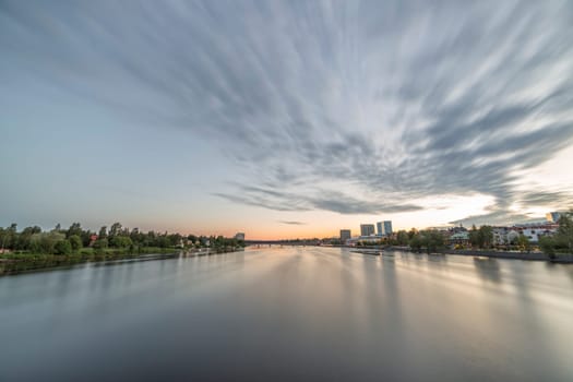 Downtown Umea, Sweden and its river with a cloudy sky at sunset.