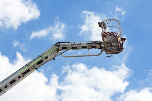 Fire truck ladder leading up into blue sky.