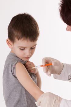Doctor giving a child injection in arm on isolated image.