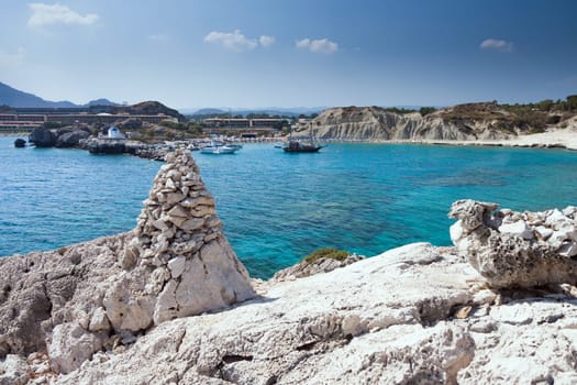 Kolymbia beach with the rocky coast in Greece. Cruise ship coming in the port.