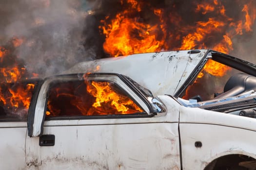 burning and then extinguish an old white car - Exercise firefighters