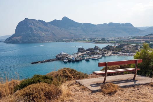 Kolymbia beach with the rocky coast in Greece. Empty bench on the island of Rhodes. View of the coast in Kolympia