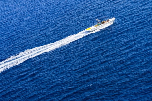 Kolymbia beach with the rocky coast in Greece. Motorboat and speed  in blue sea.