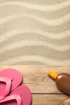 summer concept with pink flip flops and suntan oil on sandy beach