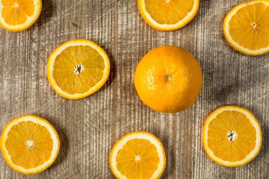 Whole orange fruit and sliced orange on wooden background