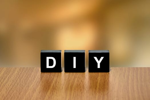 DIY or do it yourself on black block with blurred background