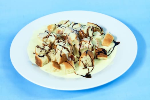 Modern food on a white plate and blue background - ducat buns with vanilla cream