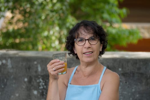 a middle-aged woman drinking orange juice