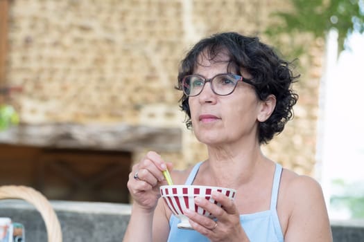 amiddle-aged woman drinking a chocolate in the garden