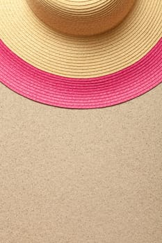 Sandy beach background with straw hat. Summer concept. Top view
