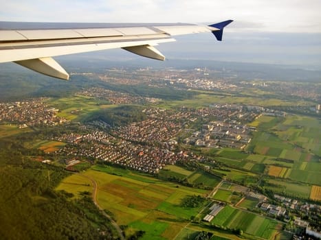 Typical german village during landing approach surrounded by fields and forest, aerial view
