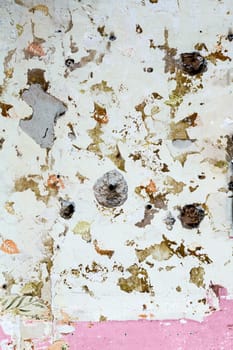 old grunge wall of an old house with remainings of color