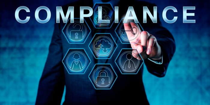 Male corporate auditor is touching the term COMPLIANCE on an interactive virtual control screen. Business challenge metaphor and corporate standard concept for meeting regulatory requirements.
