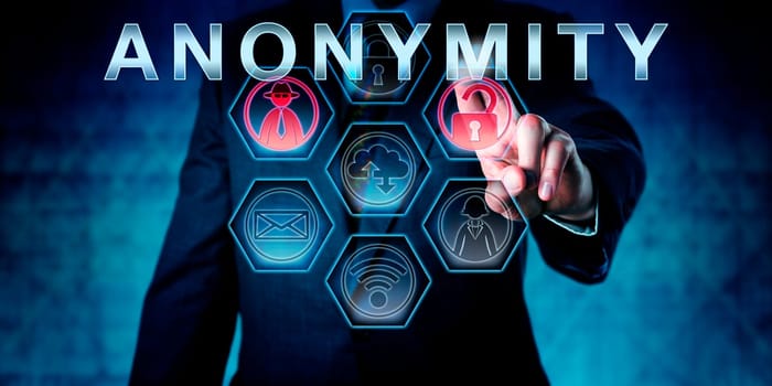 Internet services provider in blue suit is touching ANONYMITY on an interactive virtual control monitor. Business metaphor and information technology concept for anonymous internet access.