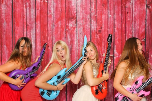 Party with photo box - girls pose with guitars in front of Photobooth