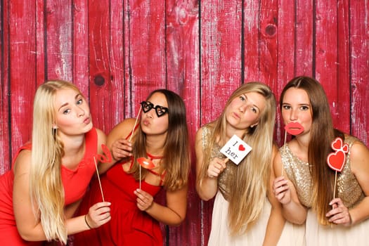 Pretty girls in front of photo box hold different probs