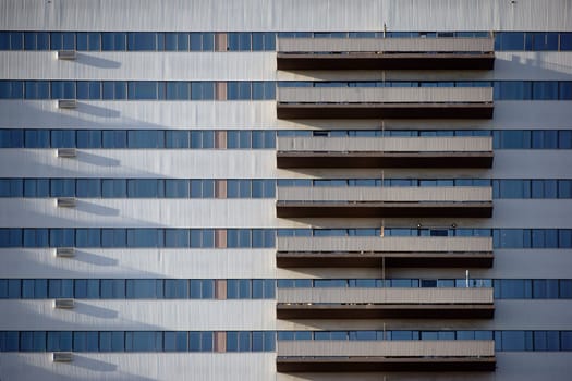 The high-rise façade of a residential and commercial building with symmetrically arranged balconies.