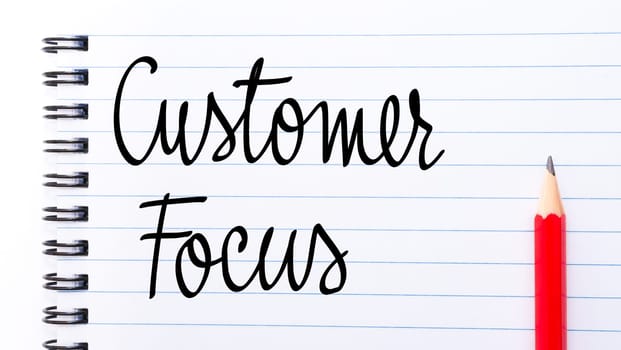 Customer Focus written on notebook page with red pencil on the right