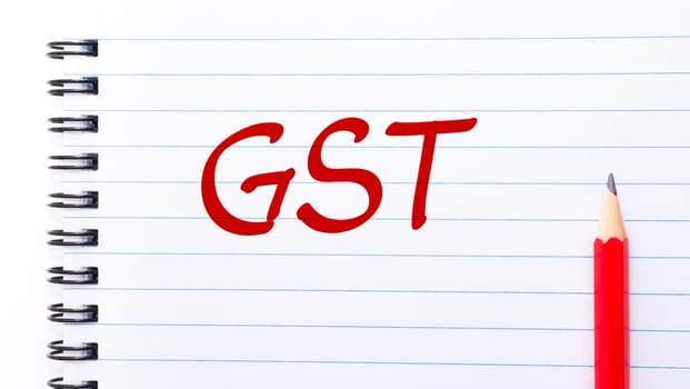 GST Goods and services tax written on notebook page with red pencil on the right