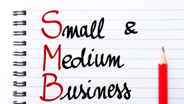 SMB Small and Medium Business written on notebook page with red pencil on the right