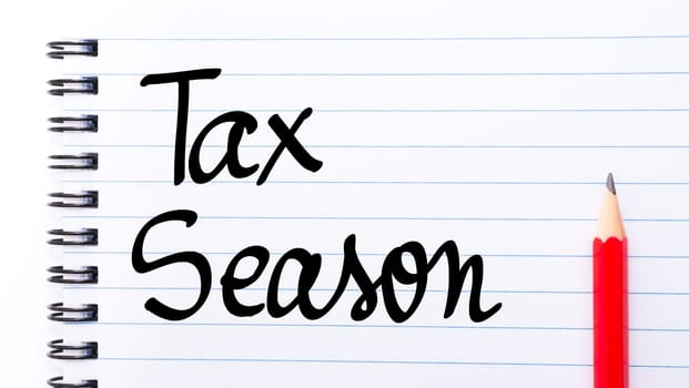 Tax Season written on notebook page with red pencil on the right
