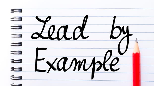 Lead By Example written on notebook page with red pencil on the right