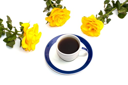 cup of coffee and three yellow roses round it