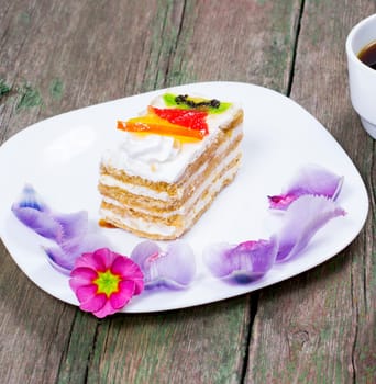 the fruit cake on a white plate decorated with flowers, a subject food and drinks