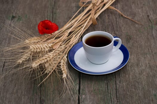 cup of black coffee, bunch of wheaten ears and flower of poppy, still life, subject beautiful flowers and drinks
