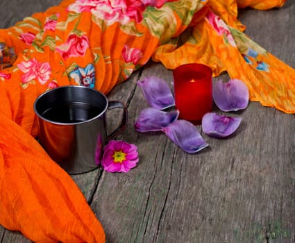 the burning candle, steel mug, orange scarf, subject food and drinks
