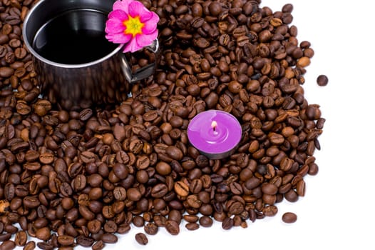 the steel mug decorated with a flower in grains of black coffee isolate, a subject drinks