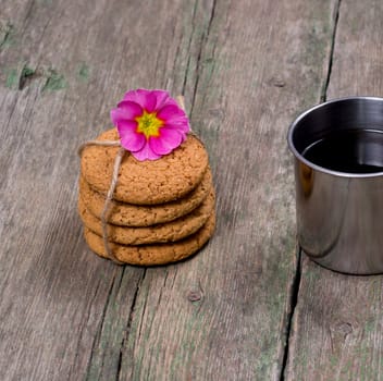 the linking of oatmeal cookies decorated with a flower on a wooden table, a subject food and drinks