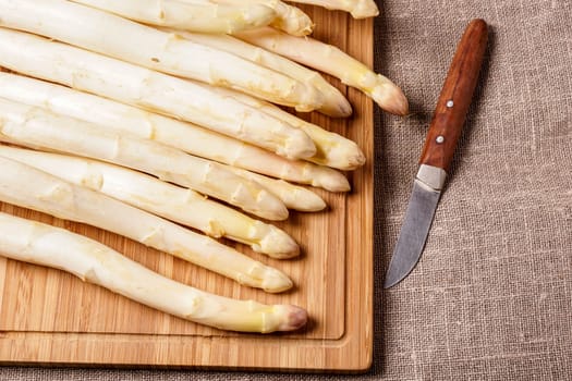 Delicate organic white asparagus ready to be peeled before they can be steamed