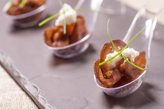 Appetizer with meat, Smoked beef and horseradish cream served on a Spoon