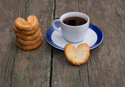 pile of cookies and cup of coffee on a wooden table, a still life on a subject drinks and sweets