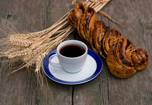 Still Life coffee, roll with poppy seeds and cereal ears, the theme of food and beverages
