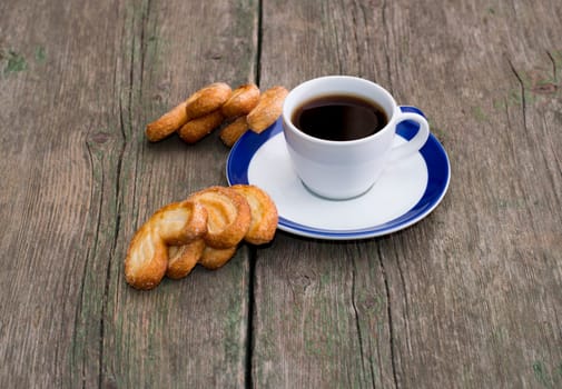 cup of coffee and two groups of cookies on a wooden table, a still life on a subject food and drinks