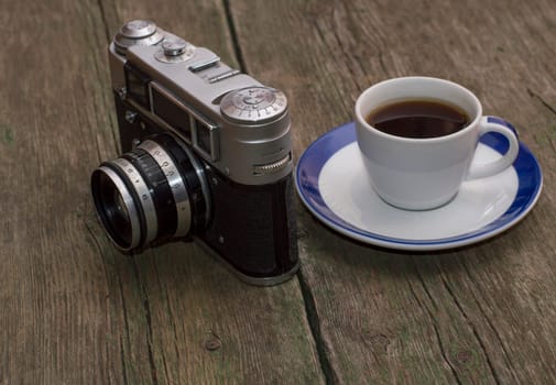 still life the old camera and coffee, on a table, a retro subject the image