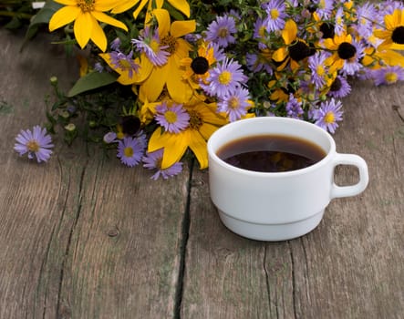 still life a cup of coffee and wild flowers on an old table, a festive card, a greeting card, a subject drinks and flowers