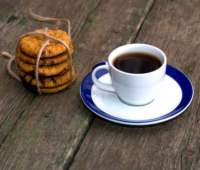 still life a cup of coffee and a linking of oatmeal cookies on an old table, a subject food and drinks