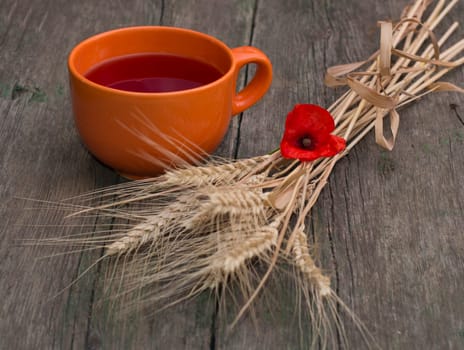 still life a clay mug with juice, wheat and a flower of poppy, a subject flowers and drinks