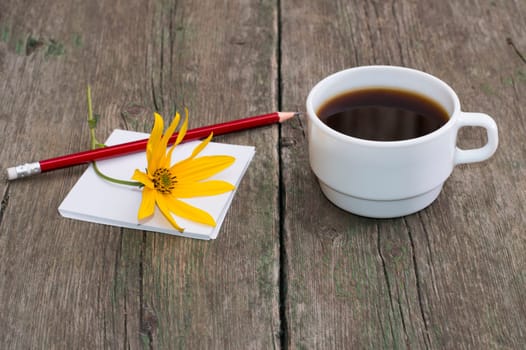still life cup of coffee, paper, pencil and yellow flower, greeting card, subject drinks and flowers