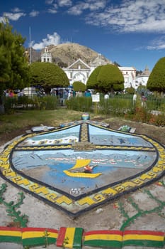 COPACABANA, BOLIVIA - JULY 28 2012: People Walking in Park and Church of Nuestra Senora de Copacabana in Background in Bolivia