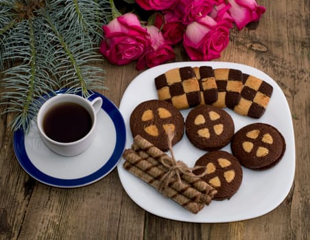 coffee, fir-tree branch, roses and a plate with baking, a still life, a subject holidays Christmas and New Year