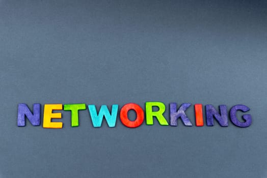 Word NETWORKING created of wood letters on dark background, business concept, copy space available