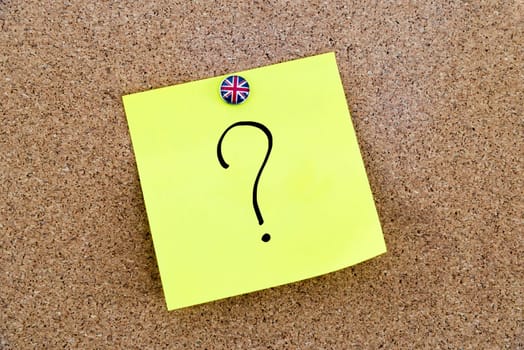 Yellow paper note pinned on cork board with Great Britain flag thumbtack, question mark, United Kingdom exit from European Union