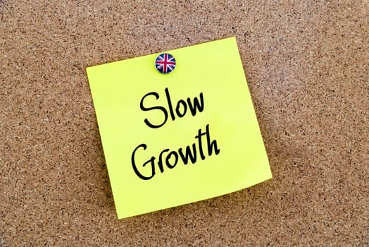 Yellow paper note pinned on cork board with Great Britain flag thumbtack, written text SLOW GROWTH , United Kingdom exit from European Union