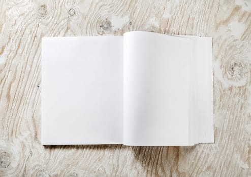 Blank opened A4 brochure magazine with soft shadows on light wooden background. Template for design portfolios. Mock-up for your design. Top view.