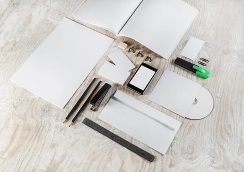 Photo of blank corporate identity template on light wooden background. Mock-up for design presentations and portfolios.
