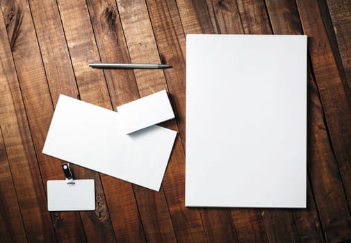 Photo of blank stationery and corporate identity template on vintage wooden table background. Branding identity template for design presentations and portfolios. Top view.